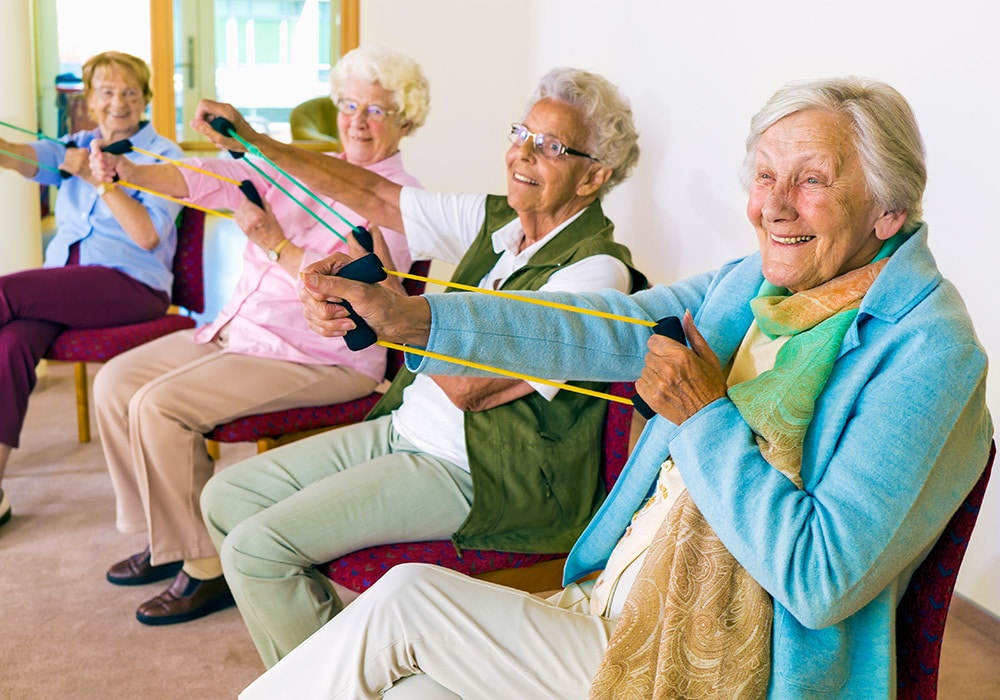 older residents sitting and exercising in post acute facility